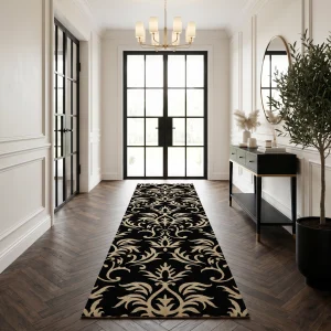 Hallway with a black-and-cream floral-patterned runner rug, white paneled walls, and a gold chandelier, ending at glass doors.