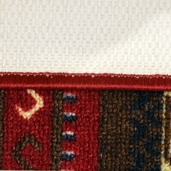 Close-up of a carpet edge with red stitching along a beige underside and a red-brown patterned rug.