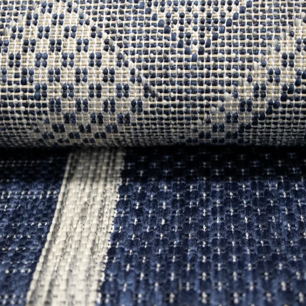 Close-up of a woven fabric with blue and beige threads creating a dotted pattern.